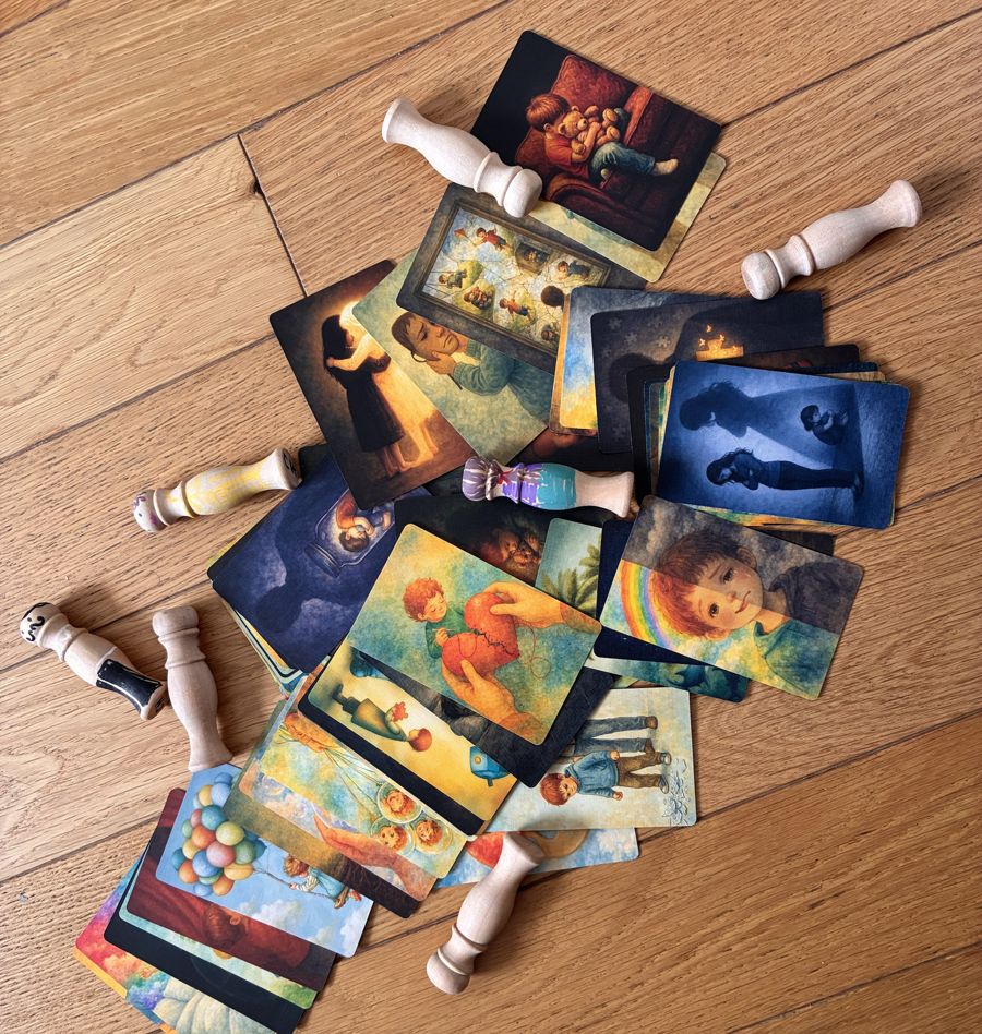 Cartes illustrées de photolangage et figurines en bois pour les constellations, posées sur le parquet